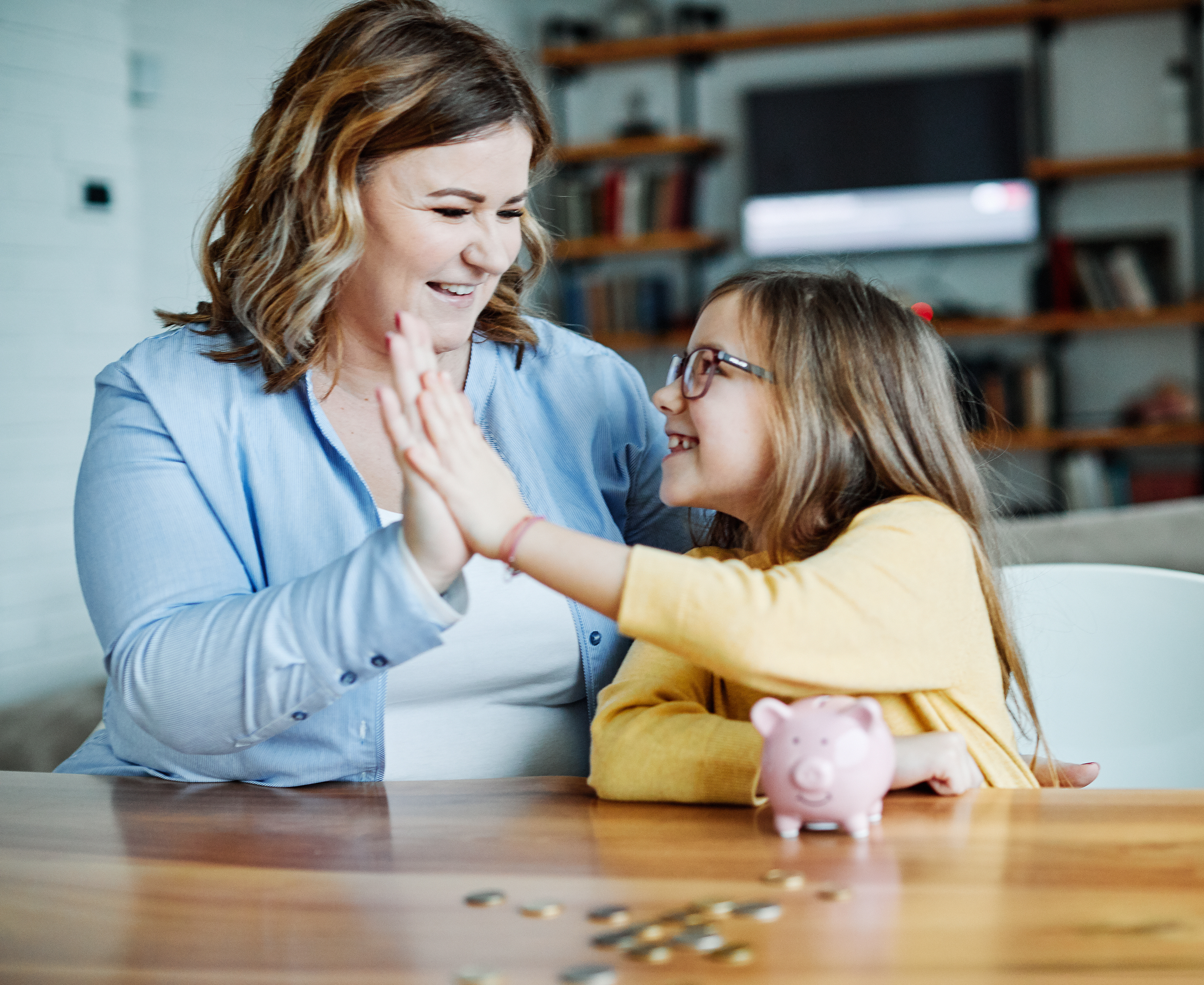 mom with daughter and piggy bank